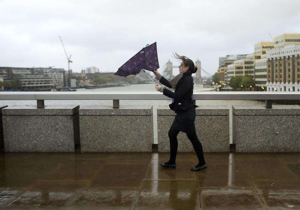 A commuter loses control of her umbrella as she braves the wind and rain while crossing London Bridge in London October 28, 2013. Strong storm winds and rain battered southern parts of England and Wales early on Monday, forcing flight cancellations, disrupting trains and closing roads and major bridges. Local media dubbed the storm "St. Jude", after the patron saint of lost causes who is traditionally celebrated on October 28. (REUTERS/Dylan Martinez)