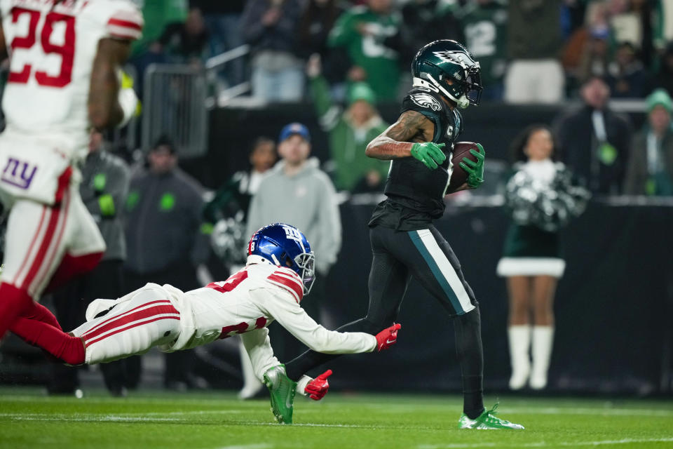 Philadelphia Eagles wide receiver DeVonta Smith scores past New York Giants cornerback Cor'Dale Flott during the first half of an NFL football game Monday, Dec. 25, 2023, in Philadelphia. (AP Photo/Matt Slocum)