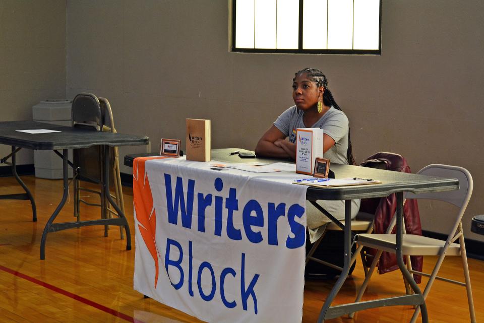 Brittany Hilderbrand, CEO of Writer's Block, a Columbia-based writing service, listens Saturday as Kunama Mtendaji (not pictured) explains the traditions of Kwanzaa through song at the Columbia Parks and Recreation Armory Sports and Recreation Center. Hilderbrand was participating in a Black-owned business expo during the pre-Kwanzaa celebration.