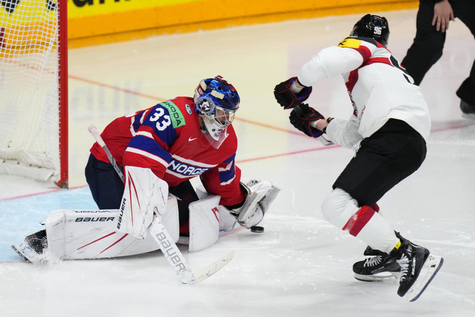 Norway's Henrik Haukeland, left, makes a save against Austria's Mario Huber during the preliminary round match between Norway and Austria at the Ice Hockey World Championships in Prague, Czech Republic, Sunday, May 19, 2024. (AP Photo/Petr David Josek)