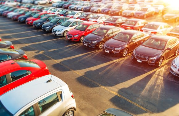 Multiple rows of cars at an automotive dealership.