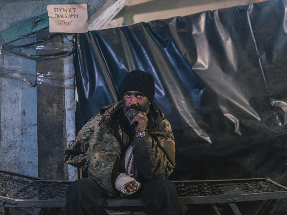 FILE - In this photo provided by Azov Special Forces Regiment of the Ukrainian National Guard Press Office, an Azov Special Forces Regiment's serviceman, injured during fighting against Russian forces, poses for a photographer inside the Azovstal steel plant in Mariupol, Ukraine, on May 10, 2022. The Ukrainian forces who made a determined last stand in a Mariupol steel mill against Russian troops were a mixture of seasoned soldiers, border guards, a controversial national guard regiment and volunteers who took up arms in the weeks before Russia's invasion. (Dmytro 'Orest' Kozatskyi/Azov Special Forces Regiment of the Ukrainian National Guard Press Office via AP)