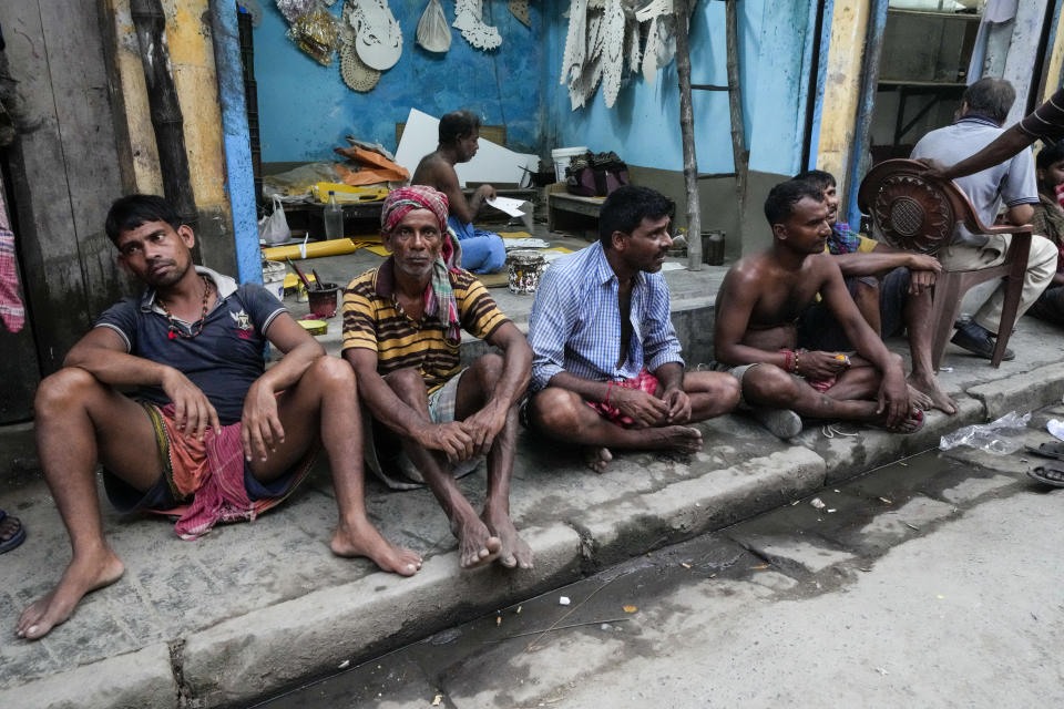 Laborers wait to load clay idols of Hindu goddess Durga at Kumortuli, the potters' place, ahead of Durga Puja festival in Kolkata, India, Sept. 27, 2022. The five-day festival commemorates the slaying of a demon king by goddess Durga, marking the triumph of good over evil. (AP Photo/Bikas Das)