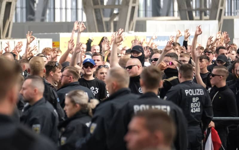 Participants of a right-wing extremist rally at the main train station show the neo-Nazi symbol of white power with their hands. Several hundred right-wing extremists demonstrated against the Christopher Street Day (CSD) taking place at the same time. Sebastian Willnow/dpa