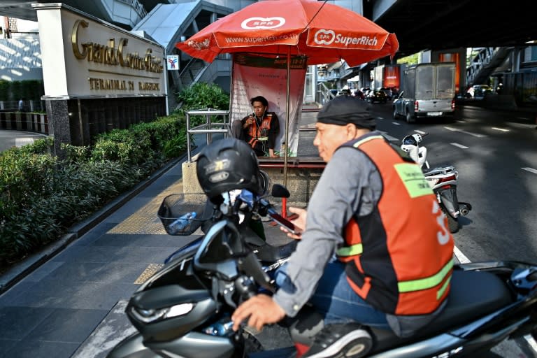 Thai motorbike delivery drivers are hard hit by soaring temperatures as as the country swelters through a heatwave (MANAN VATSYAYANA)