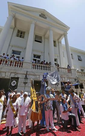 Rio de Janeiro's Mayor Eduardo Paes (2nd R) and Rei Momo, or Carnival King Wilson Neto (C) poses for pictures during the handing over of the ceremonial key to the city, at Cidade Palace in Rio de Janeiro February 13, 2015. REUTERS/Sergio Moraes