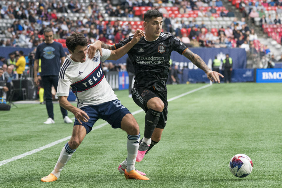 Vancouver Whitecaps' Alessandro Schopf, left, and Houston Dynamo FC's Franco Escobar compete for the ball during the first half of an MLS soccer match Wednesday, May 31, 2023, in Vancouver, British Columbia. (Rich Lam/The Canadian Press via AP)
