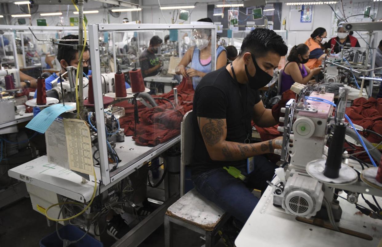 Employees at the K.P. Textil textile plant in Guatemala City. <a href="https://www.gettyimages.com/detail/news-photo/workers-wear-face-masks-as-a-preventive-measure-against-the-news-photo/1226220586?adppopup=true" rel="nofollow noopener" target="_blank" data-ylk="slk:Johan Ordonez/AFP via Getty Images);elm:context_link;itc:0;sec:content-canvas" class="link ">Johan Ordonez/AFP via Getty Images)</a>