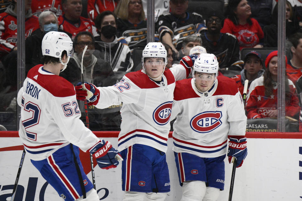 Montreal Canadiens right wing Cole Caufield (22) celebrates with defenseman Justin Barron (52) and center Nick Suzuki (14) in the second period after scoring his second goal of an NHL hockey game against the Washington Capitals, Saturday, Dec. 31, 2022, in Washington. (AP Photo/Nick Wass)