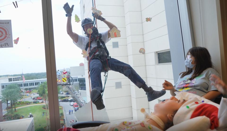 Firefighters and police officers surprised children and their families in the sixth annual Holiday Elf rappelling event.