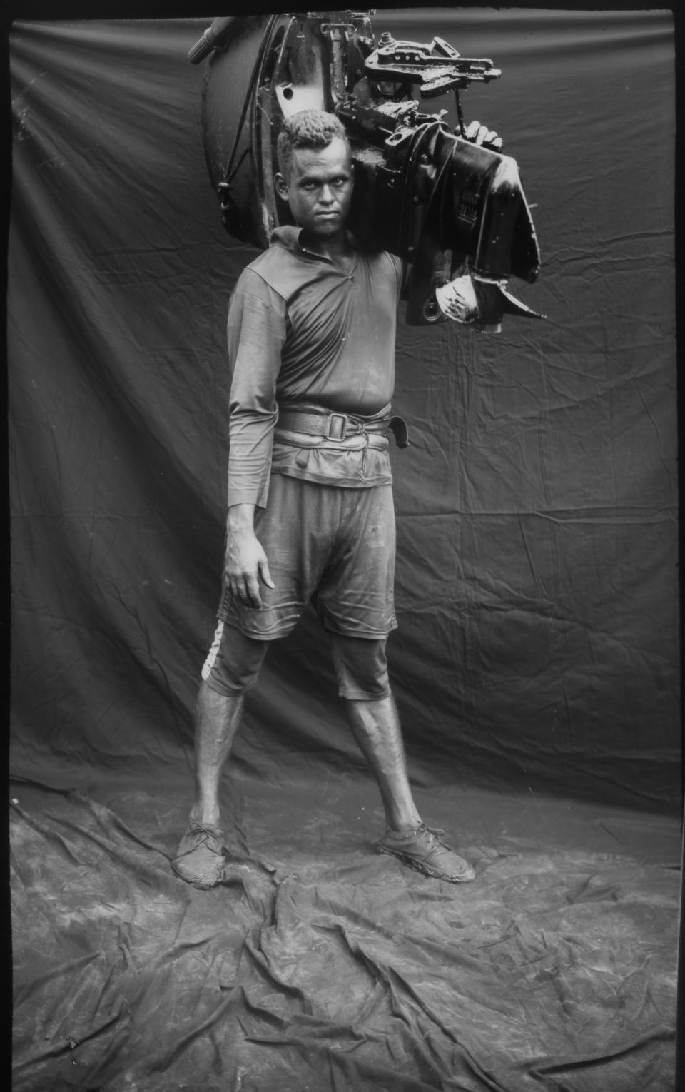 A fisherman's assistant poses for a portrait after working on oil-contaminated Lake Maracaibo in Cabimas, Venezuela. (Photo: Rodrigo Abd/AP)