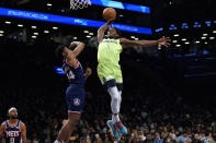 Minnesota Timberwolves forward Anthony Edwards (1) dunks past Brooklyn Nets guard Cam Thomas (24) during the first half of an NBA basketball game Friday, Dec. 3, 2021, in New York. (AP Photo/Mary Altaffer)