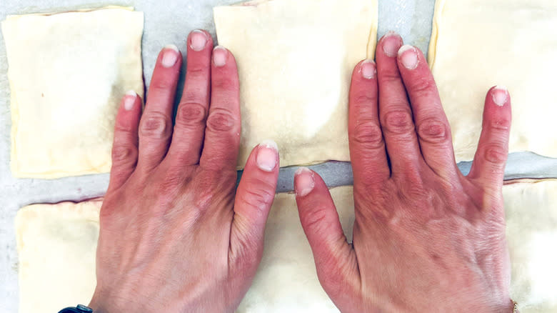 hands patting pastry dough