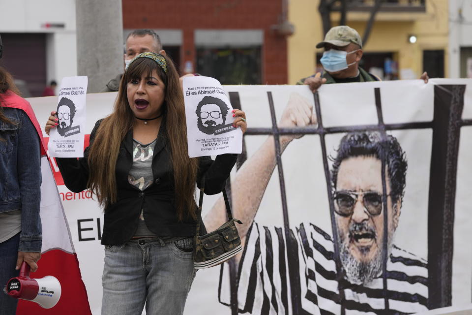 People gather outside the anti-terrorism directorate to celebrate the death of Abimael Guzman, founder and leader of the Shining Path guerrilla movement, in Lima, Peru, Saturday, Sept. 11, 2021. Guzman, who was captured in 1992, died on Saturday in a military hospital after an illness, the Peruvian government said. He was 86. (AP Photo/Martin Mejia)