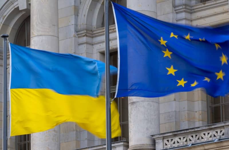 The national flag of Ukraine and the flag of the EU are flying in the wind. Monika Skolimowska/dpa