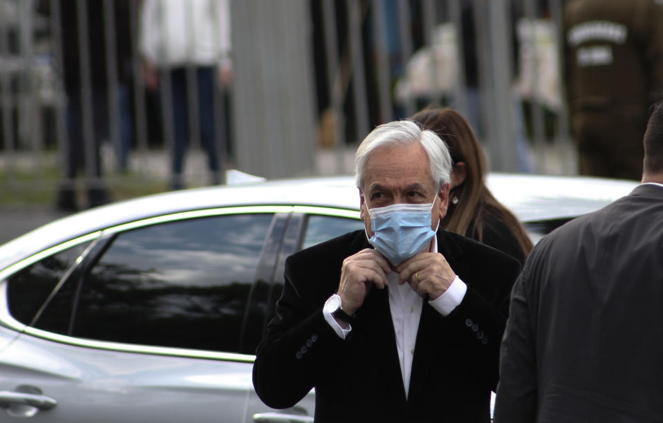 Chilean President Sebastian Pinera arrives at a polling station to vote in Santiago, Chile, Sunday, Oct. 25, 2020. Amid a year of contagion and turmoil, Chileans vote Sunday on whether to draft a new constitution for their nation to replace guiding principles imposed four decades ago under a military dictatorship.(AP Photo/Esteban Felix)