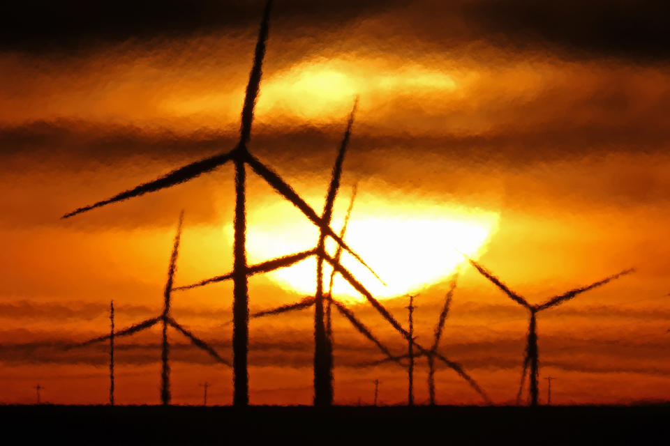 FILE - Wind turbines are silhouetted against the rising sun Wednesday, Jan. 13, 2021, near Spearville, Kan. A new study released on Wednesday, April 13, 2022, finds that if the nations of the world live up to their promises, future climate climate change can be limited to the weaker of two international goals. According to a study, the world is potentially on track to keep global warming at or a shade below 2 degrees Celsius (3.6 degrees Fahrenheit) hotter than pre-industrial times, a goal that once seemed out of reach (AP Photo/Charlie Riedel, File)