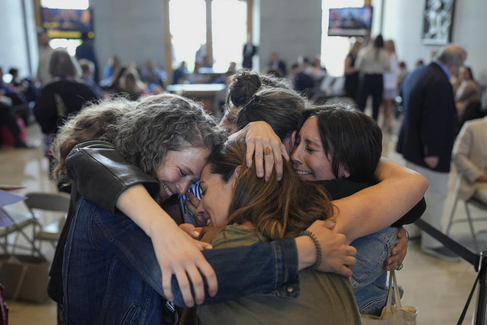 Protesters Becca Dryden, left, Erica Bowton, and Ashley Warbington, right, hug outside the House chamber Thursday, April 25, 2024, in Nashville, Tenn. The group of women were removed from the chamber after displaying a banner in the gallery during a legislative session. (AP Photo/George Walker IV)