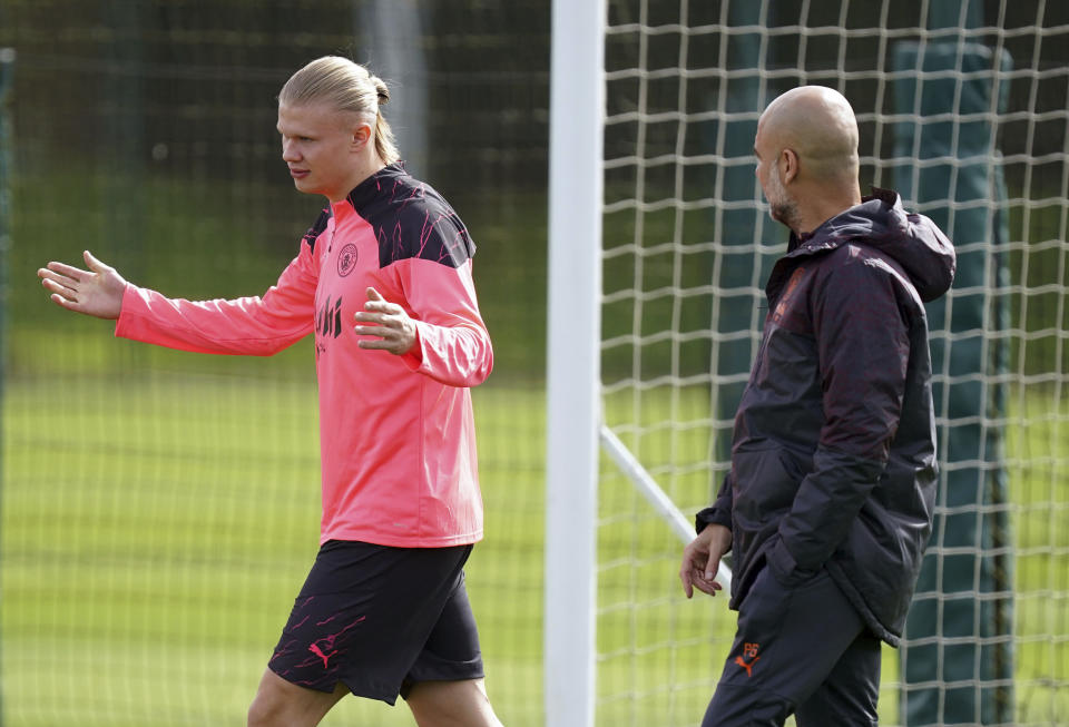 Erling Haaland (izquierda) del Manchester City charla con el técnico Pep Guardiola durante un entrenamiento, el lunes 8 de abril de 2024. (Mike Egerton/PA via AP)