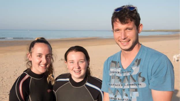 The teenagers posing with passerby Keith Gray who helped them get the man out of the water. (RNLI Fraserburgh)