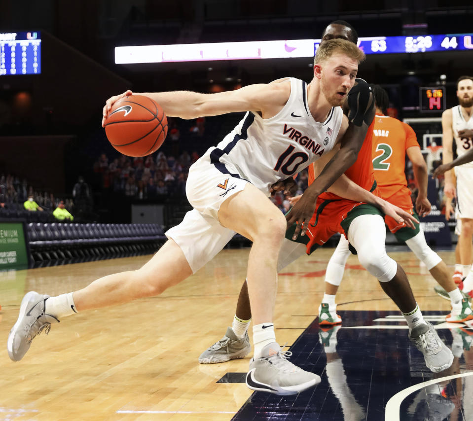 Virginia forward Sam Hauser (10) drives past Miami guard Elijah Olaniyi (4) during an NCAA college basketball game, Monday, March 1, 2021, in Charlottesville, Va. (Andrew Shurtleff/The Daily Progress via AP, Pool)