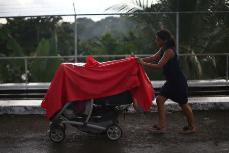 A Central American migrant, part of a caravan trying to reach the U.S, pushes a pram on the bridge that connects Mexico and Guatemala in Ciudad Hidalgo, Mexico, October 21, 2018. REUTERS/Edgard Garrido