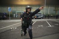 In this Monday, Oct. 14, 2019 photo, a Spanish police gives instructions to other police members, not pictured, during a demonstration at El Prat airport, outskirts of Barcelona, Spain. Riot police engaged in a running battle with angry protesters outside Barcelona's airport Monday after Spain's Supreme Court convicted 12 separatist leaders of illegally promoting the wealthy Catalonia region's independence and sentenced nine of them to prison. (AP Photo/Joan Mateu)