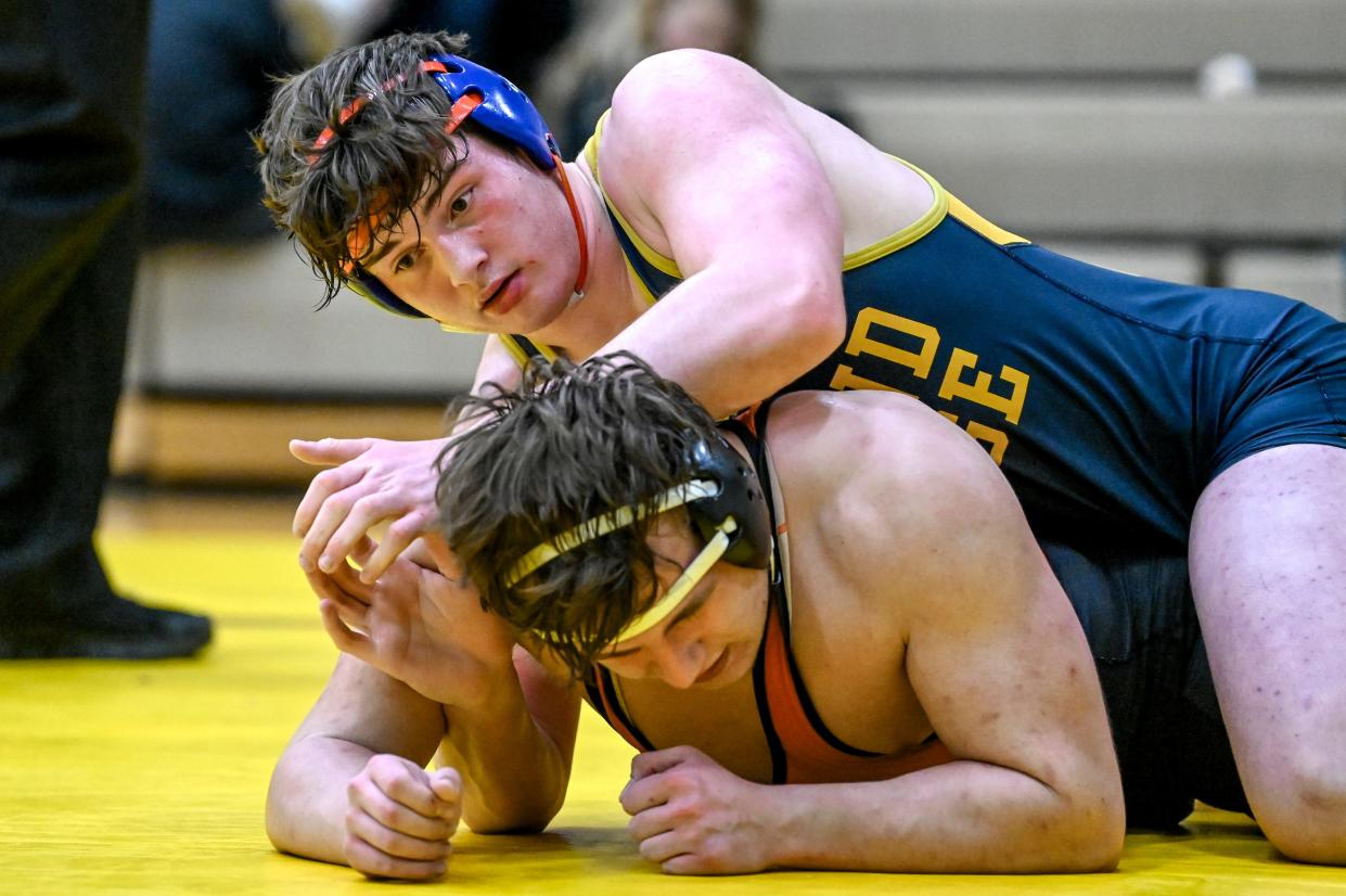 Grand Ledge's Logan Tollison, top, wrestles with Jackson's Reece Deshazor in the 215-pound match during the Division 1 district final on Wednesday, Feb. 7, 2024, at Holt Jr. High School. Tollison won the match.
