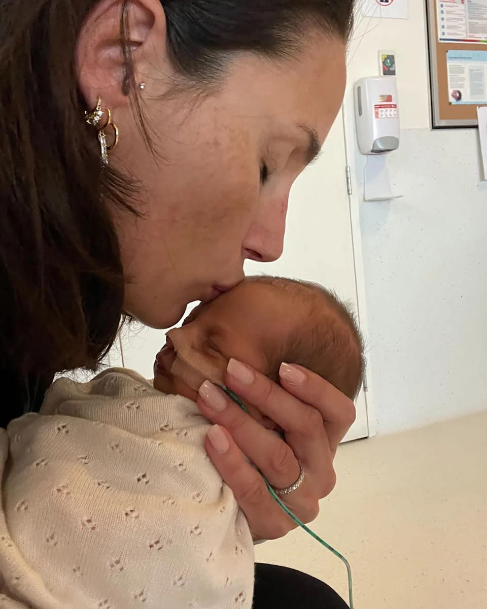Snezana Wood kisses her fourth child, baby Harper Jones Wood, on the forehead. 