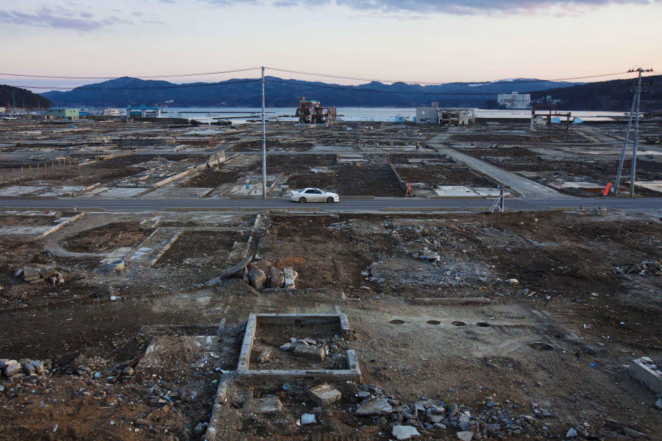 In this Feb. 23, 2012, file photo, a car passes through the leveled city of Minamisanriku, Miyagi Prefecture, northeastern Japan, almost one year after the March 11 tsunami. (AP Photo/David Guttenfelder, File)