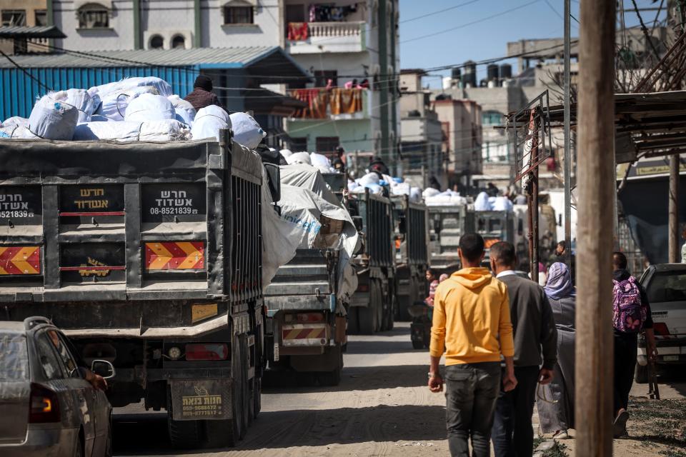 Trucks carrying humanitarian aid make their way along a street in Rafah in the southern Gaza Strip on March 10, 2024.