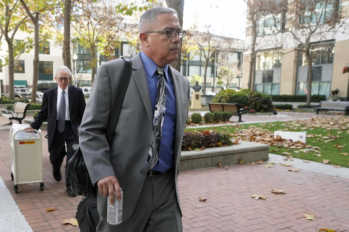 Ray J. Garcia, foreground, and his defense lawyer, James Reilly, leave the Federal Courthouse in Oakland, Calif., Monday, Nov. 28, 2022. Garcia, the former warden of an abuse-plagued federal women's prison known as the "rape club," went on trial Monday, accused of molesting inmates and forcing them to pose naked in their cells. (AP Photo/Jeff Chiu)