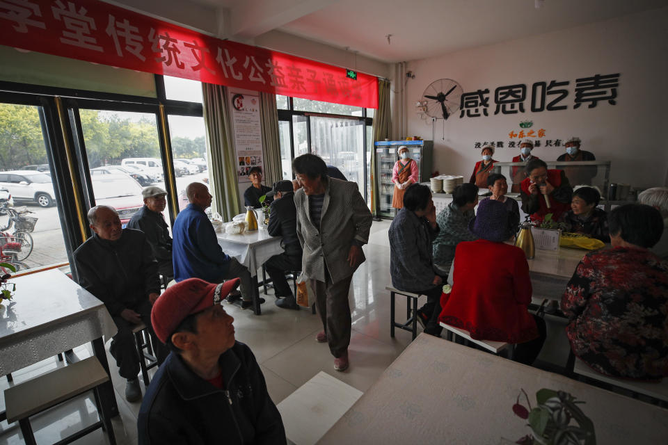 Elderly people take a seat at Kang's canteen, the Harmonious and Happy Home for free vegetarian lunch in Dingxing, southwest of Beijing Thursday, May 13, 2021. China's leaders are easing limits on how many children each couple can have, hoping to counter the rapid aging of Chinese society.(AP Photo/Andy Wong)