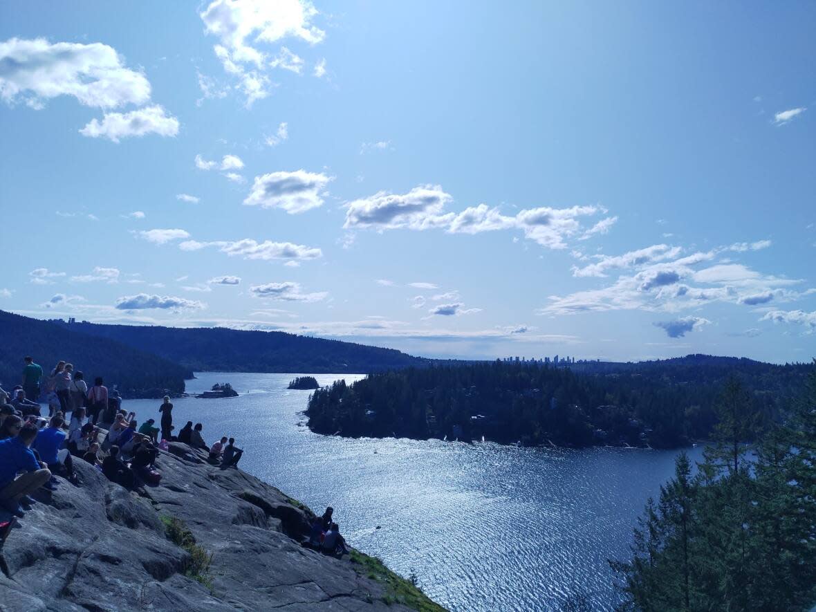 Trail users at the top of Quarry Rock are pictured in September 2019. The rock grants a view of Deep Cove and the surrounding area, making it a popular destination for outdoor enthusiasts in Metro Vancouver. (Akshay Kulkarni/CBC - image credit)