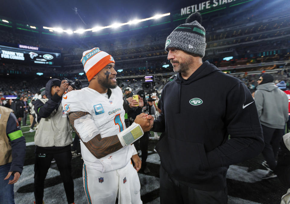 Miami Dolphins quarterback Tua Tagovailoa (1) interacts with New York Jets quarterback Aaron Rodgers (8) after the team's win over the New York Jets during an NFL football game Friday, Nov. 24, 2023, in East Rutherford, N.J. (David Santiago/Miami Herald via AP)