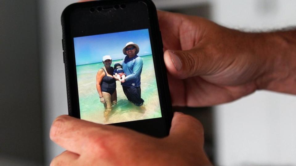 Foto a la foto de un celular con familias víctimas del colapso de un edificio en Miami.