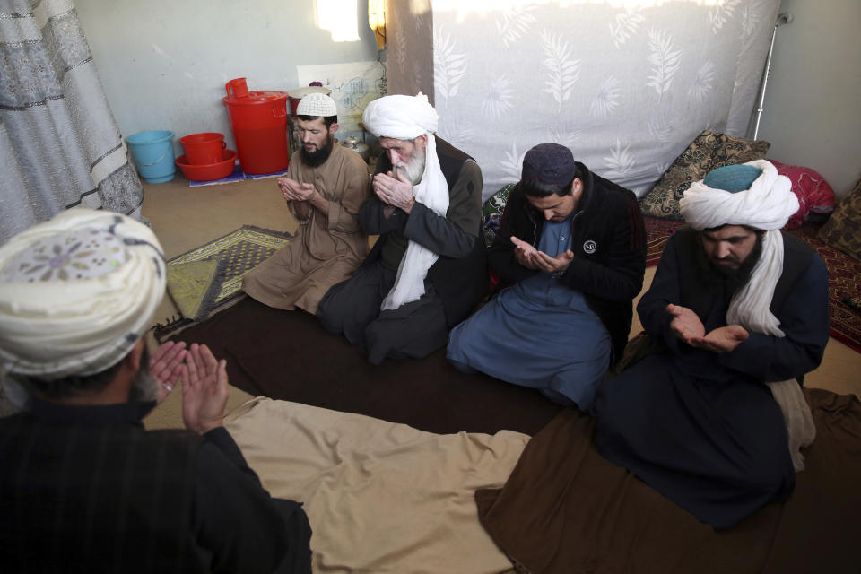 FILE - In this Dec. 14, 2019 file photo, jailed Taliban pray inside the Pul-e-Charkhi Jail, in Kabul, Afghanistan. Afghanistan’s largest prison, Pul-e-Charkhi, was built in the 1970s to house 5,000 prisoners but now holds 10,500. In some cells in Afghanistan, Iran, Egypt, Syria and other countries in the Middle East, prisoners are crammed in by the dozens, with little access to hygiene or medical care. So if one infection gets in, the novel coronavirus could run rampant. (AP Photo/Rahmat Gul, File)