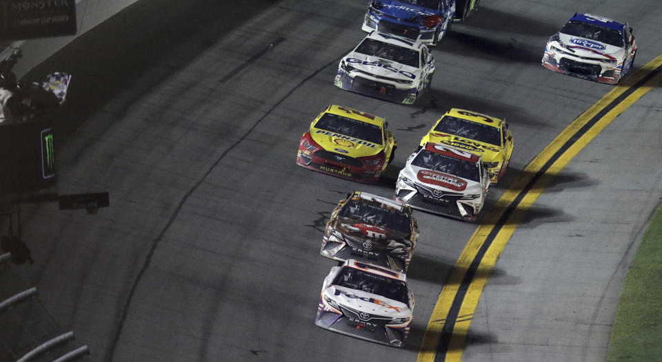 Denny Hamlin (11) takes the checkered flag to win the NASCAR Daytona 500 auto race Sunday, Feb. 17, 2019, at Daytona International Speedway in Daytona Beach, Fla. (AP Photo/David Graham)