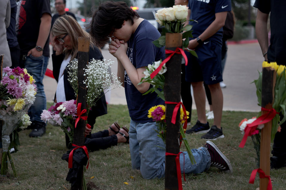 People pray at a memorial next to the Allen Premium Outlets in Allen, Texas, on May 7, 2023.<span class="copyright">Joe Raedle—Getty Images</span>