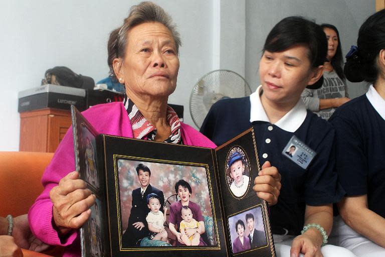 Grieving Indonesian mother Suharni displays a portrait of her son Sugianto Lo and his wife Vinny Chynthya who are both passengers of the missing Malaysia Airlines flight in Medan, Sumatra island on March 10, 2013