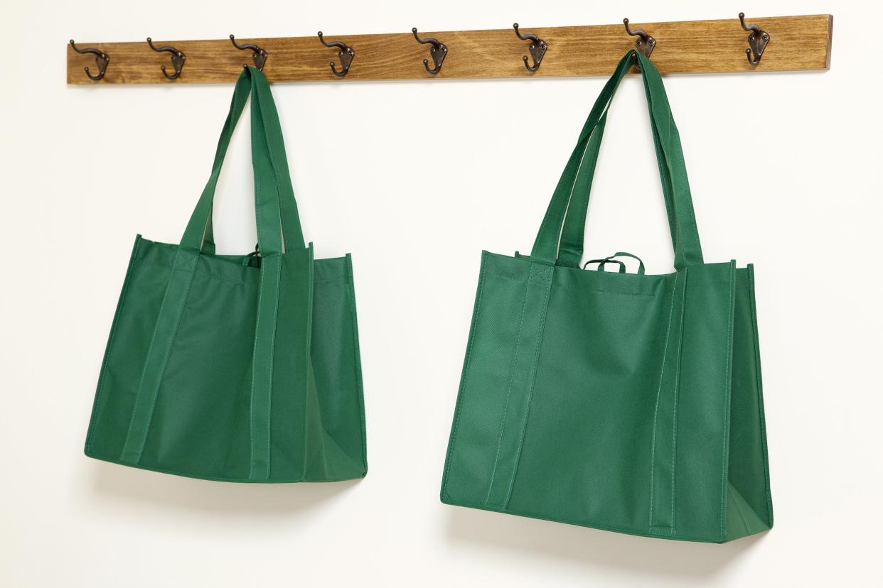 Two reusable shopping bags hanging on a wall