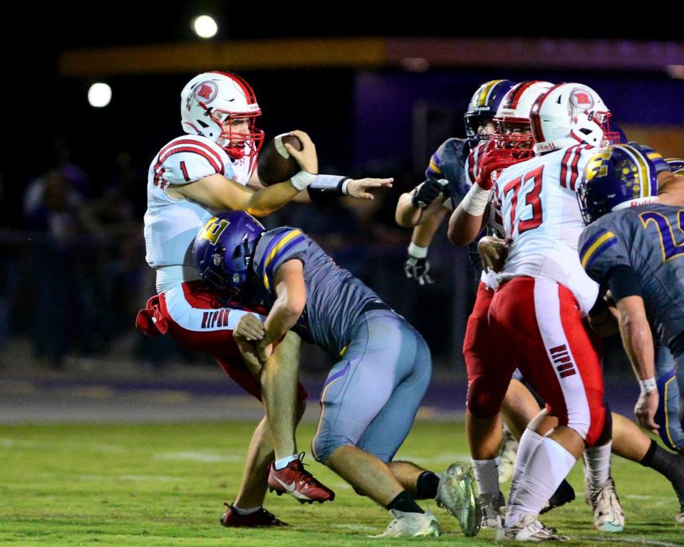 Ripon quarterback Ty Herrin (1) gets taken down by an Escalon defender during a game between Escalon High School and Ripon High School in Escalon, California on October 20, 2023. 