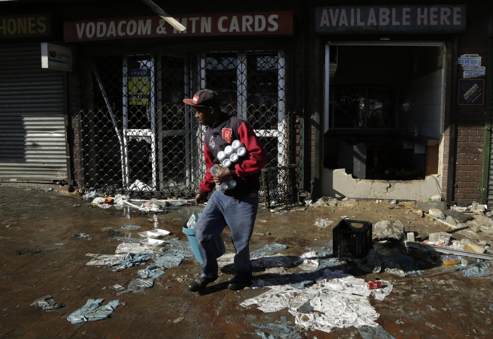 A looter makes off with goods from a store in Germiston, east of Johannesburg, South Africa, Tuesday, Sept. 3, 2019. Police had earlier fired rubber bullets as they struggled to stop looters who targeted businesses as unrest broke out in several spots in and around the city. (AP Photo/Themba Hadebe)