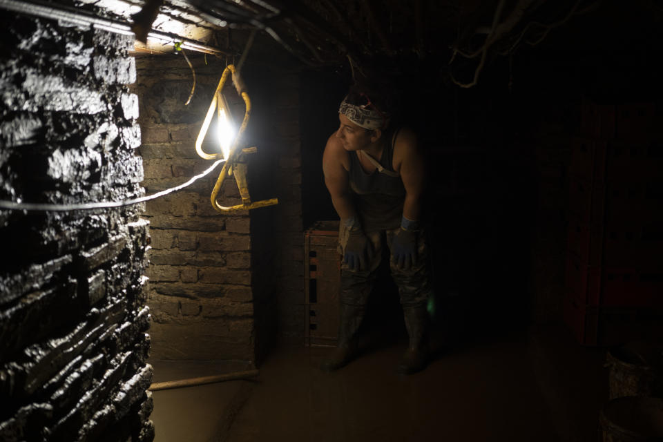 Paddy Amanatidis stands in the basement of her restaurant that was flooded in Bad Neuenahr-Ahrweiler, Germany, Monday July 19, 2021. More than 180 people died when heavy rainfall turned tiny streams into raging torrents across parts of western Germany and Belgium, and officials put the death toll in Ahrweiler county alone at 110. (AP Photo/Bram Janssen)