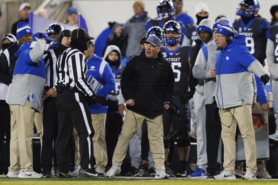 Kentucky head coach Mark Stoops, middle, complains to an official about an intentional grounding call during the second half of an NCAA college football game against Georgia in Lexington, Ky., Saturday, Nov. 19, 2022. (AP Photo/Michael Clubb)