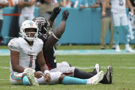 Miami Dolphins quarterback Tua Tagovailoa (1) and Atlanta Falcons defensive tackle Grady Jarrett (97) react after a pass thrown by Tagovailoa was intercepted, during the second half of an NFL football game, Sunday, Oct. 24, 2021, in Miami Gardens, Fla. (AP Photo/Hans Deryk)