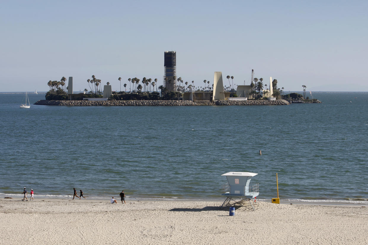 A new tower undergoing construction (C) and a temporary drill rig (R) is seen among various structures and palm trees that are used to hide oil extraction operations on Island White, one of four such oil drilling islands operated by THUMS Long Beach Company, which is owned by Occidental Petroleum Corporation (Oxy), in Long Beach, California July 30, 2013. (ENERGY BUSINESS CONSTRUCTION)