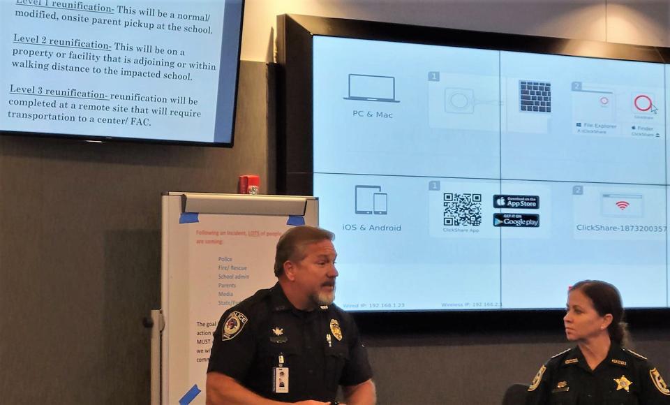 Three levels of how and where parents will be reunited (on screen) with their children in the event of a Clay County school shooting were presented to Tynes Elementary School staff by school district Safety Director Steve Mills (left) and Sheriff Michelle Cook.