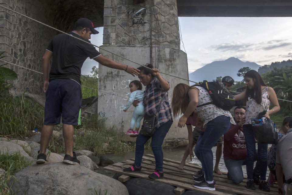 A raft operator helps his passenger on the Mexican side of the Suchiate river in Talisman, Mexico, Friday, June 21, 2019. Mexico's foreign minister says that the country has completed its deployment of some 6,000 National Guard members to help control the flow of Central American migrants headed toward the U.S. (AP Photo/Oliver de Ros)