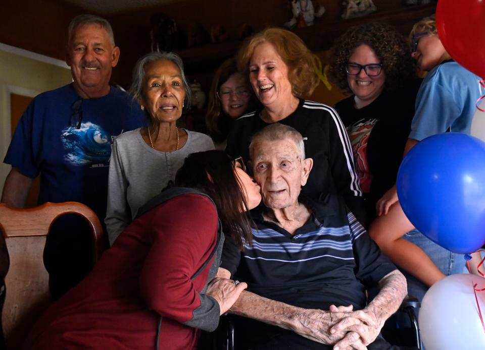 Trae Booth kisses her father Dwight Painter as most of his family gathers around for a family photo on his 95th birthday Nov. 11.